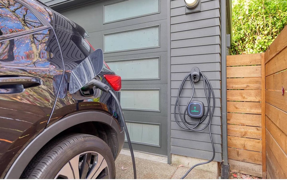 Wallbox EV charger mounted by garage with electric vehicle charging