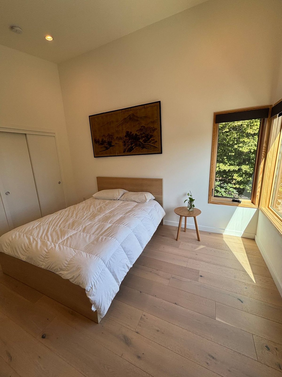 Queen bedroom with minimalist decor, Japanese art, and natural light