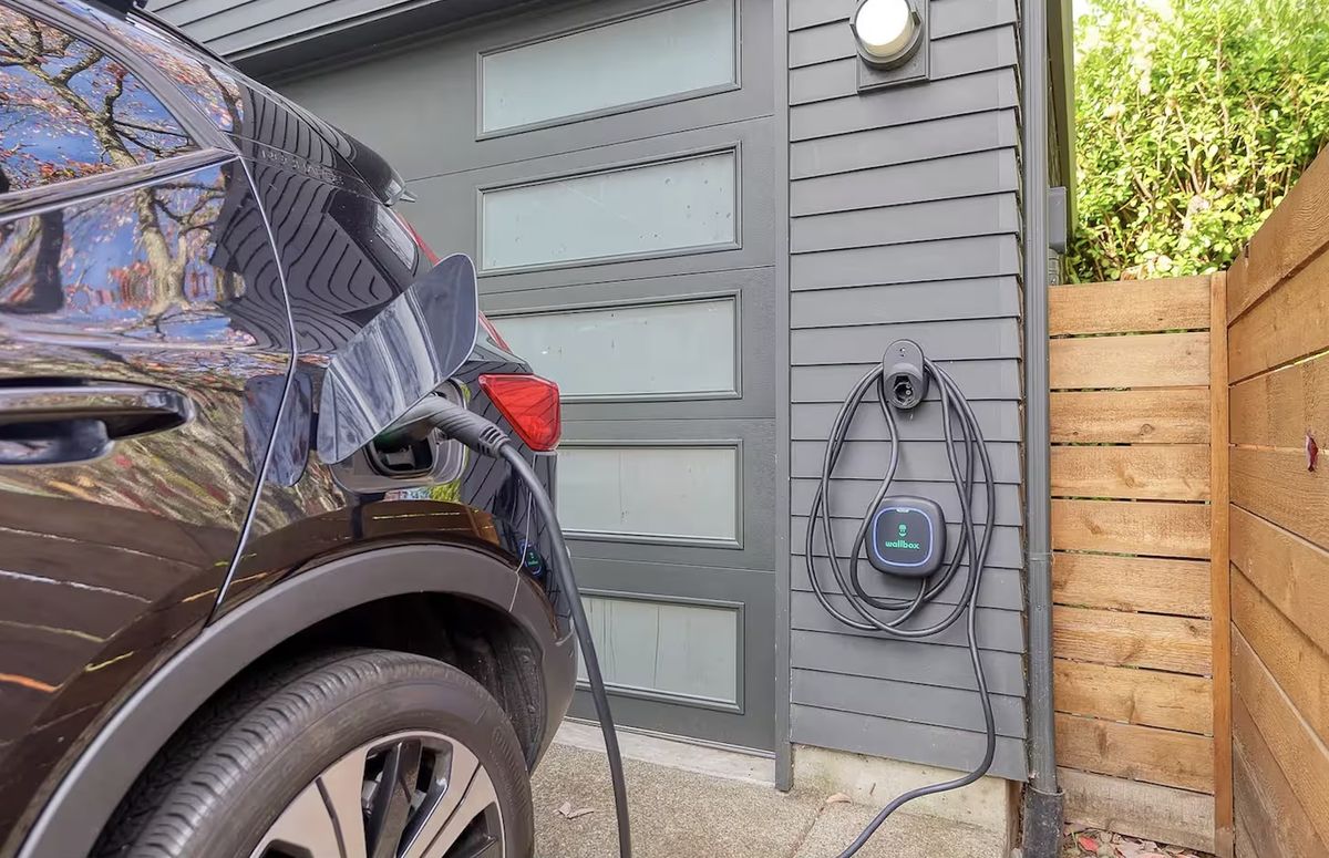 Wallbox EV charger mounted by garage with electric vehicle charging